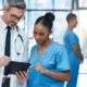 Intensivist and nurse working together on a tablet to review patient vitals