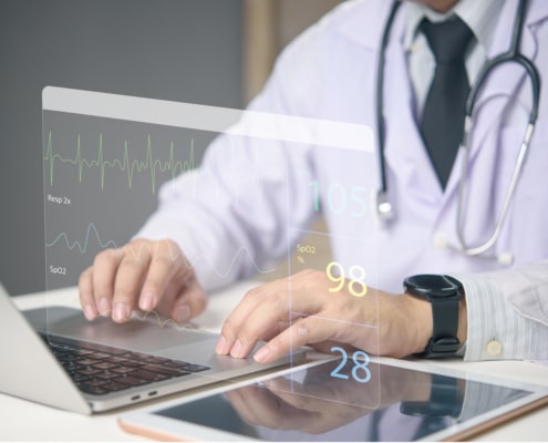 Doctor working on laptop with medical dashboard ECG, SpO2, and vital signs real-time healthcare monitoring. Advanced health technology data screen, telemedicine and smart hospital systems.