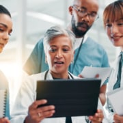 Physicians and nurse in hospital looking at tablet for results. Healthcare, teamwork and virtual critical care tech for physician outsourcing support